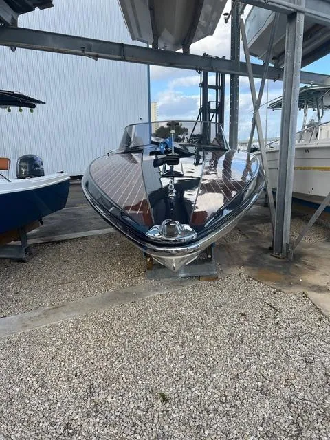 Slide: The Image of 1977 Riva 310 boat with sleek design, docked under a metal shelter. - 13