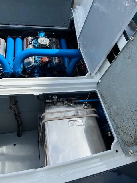 Slide: The Image of 1977 Riva 310 engine compartment with blue components and metal tank. - 23