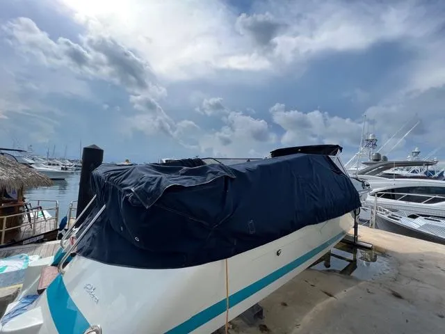 Slide: The Image of 1977 Riva 310 boat covered at marina, cloudy sky background. - 25