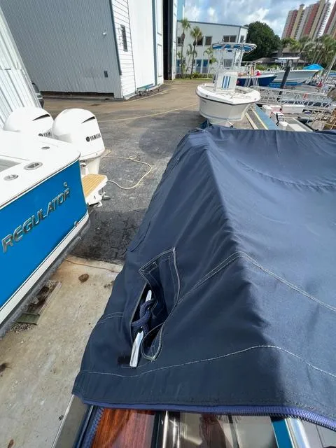 Slide: The Image of 1977 Riva 310 boat with blue cover docked near other boats. - 26