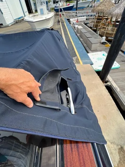 Slide: The Image of Hand opening cover on 1977 Riva 310 boat docked at marina. - 27