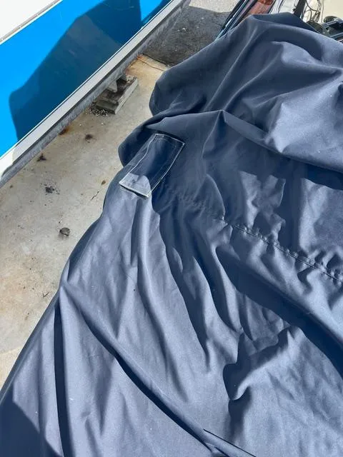 Slide: The Image of Covered 1977 Riva 310 boat with blue tarp in storage. - 29