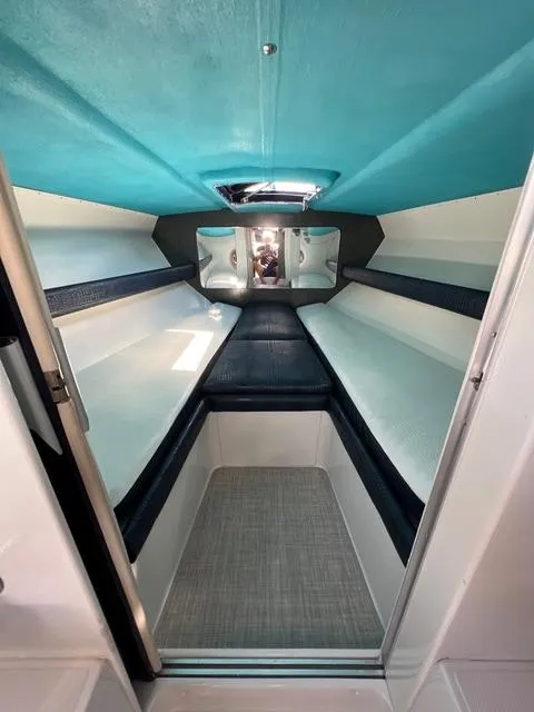 Slide: The Image of Interior of a 1977 Riva 310 boat with turquoise ceiling and white seating. - 7