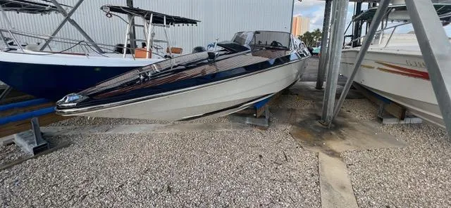 Slide: The Image of 1977 Riva 310 boat on dry dock, sleek design, parked among other boats. - 8