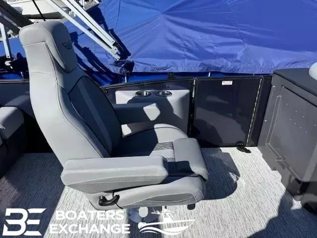Slide: The Image of 2025 Bennington 22MSBSE boat interior with gray captain's chair and blue canopy. - 6