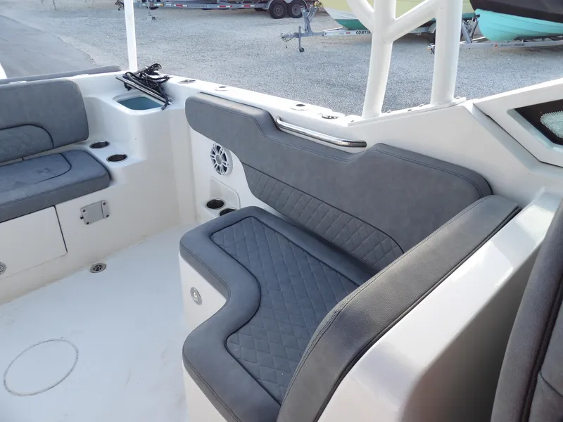 Slide: The Image of 2022 Stingray 269 DC boat interior with gray cushioned seating and storage compartments. - 15