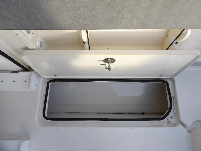 Slide: The Image of Storage compartment in 2022 Stingray 269 DC boat, open lid, white interior. - 22