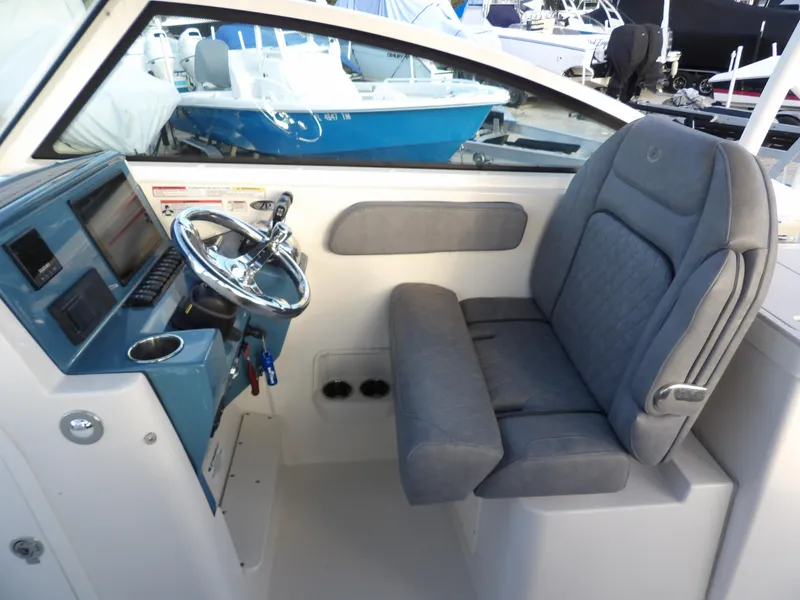 Slide: The Image of 2022 Stingray 269 DC boat interior with steering wheel and cushioned seat. - 27