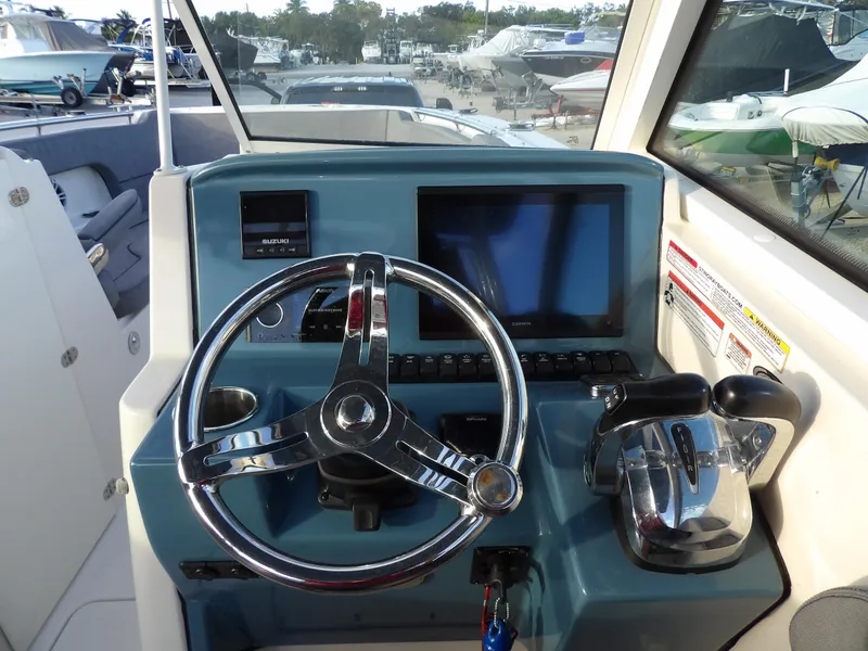 Slide: The Image of Dashboard of a 2022 Stingray 269 DC boat with steering wheel and controls. - 28