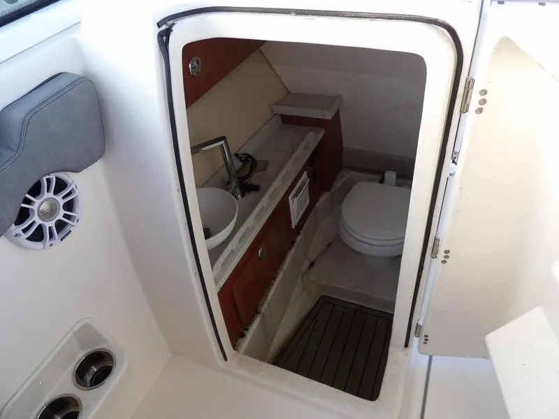 Slide: The Image of 2022 Stingray 269 DC boat interior with compact bathroom, featuring a sink and toilet. - 39