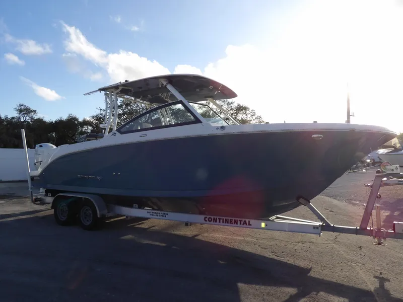 Slide: The Image of 2022 Stingray 269 DC boat on trailer under bright sky. - 4