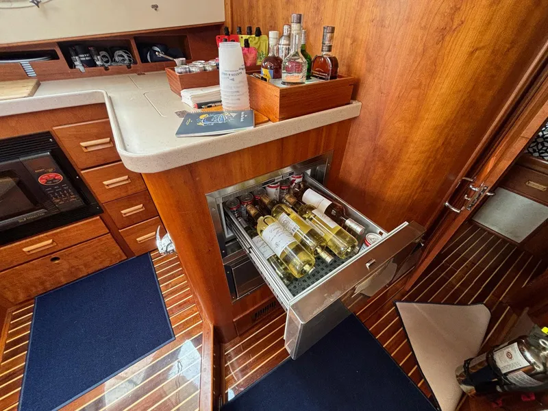 Slide: The Image of Hinckley Talaria 44 MY 2005 yacht interior with open wine drawer and wooden cabinetry. - 11