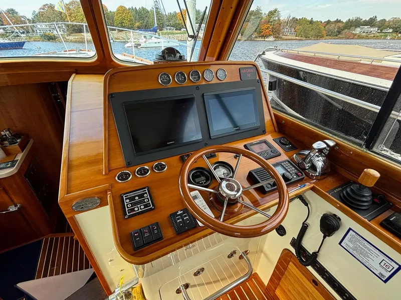 Slide: The Image of Helm of 2005 Hinckley Talaria 44 MY with wooden dashboard and modern navigation equipment. - 14