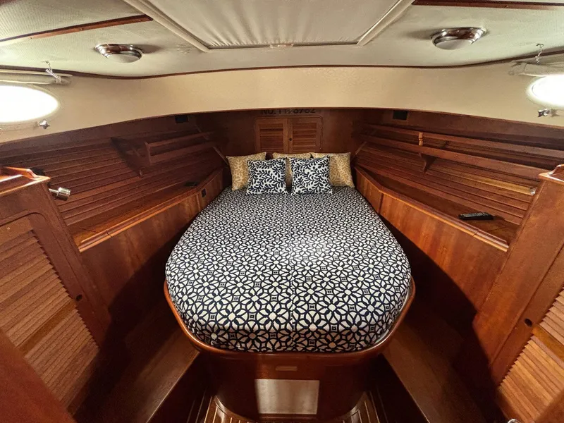 Slide: The Image of Luxurious 2005 Hinckley Talaria 44 MY cabin with elegant wood finish and patterned bedding. - 5