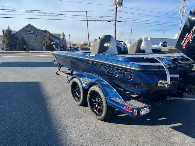 Slide: The Image of 2025 Nitro Z20 XL Pro boat, blue, parked outdoors on a sunny day. - 2