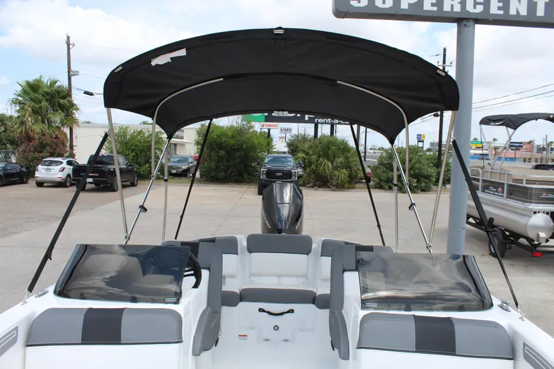 Slide: The Image of 2025 Tahoe T21 boat with canopy, parked outdoors at a dealership. - 12