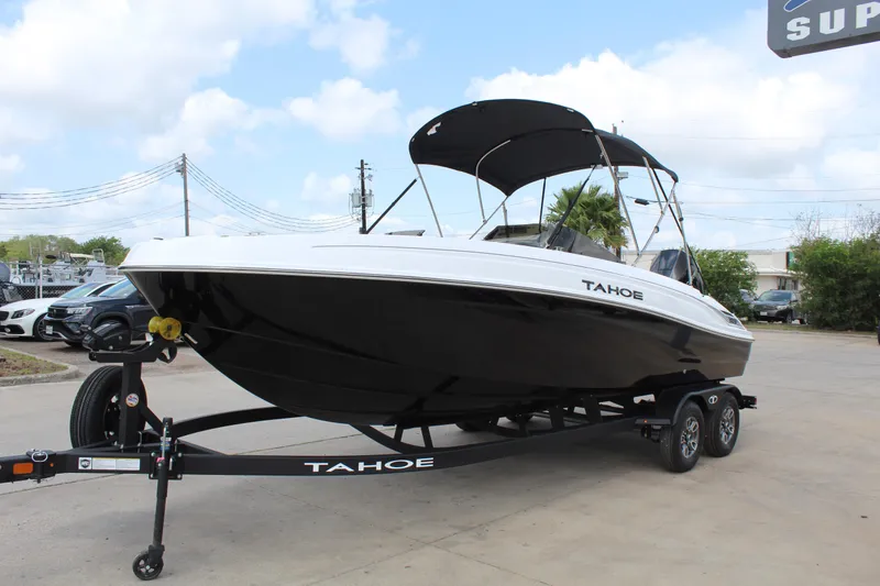 Slide: The Image of 2025 Tahoe T21 boat on trailer, black and white design, parked outdoors. - 3