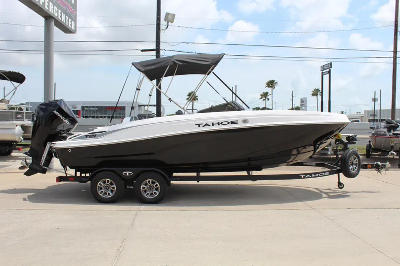 Slide: The Image of 2025 Tahoe T21 boat on trailer, parked outdoors under a cloudy sky. - 4