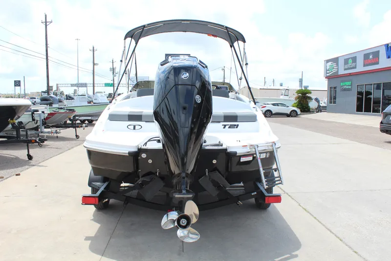 Slide: The Image of 2025 Tahoe T21 boat with outboard motor on trailer, parked outdoors. - 6