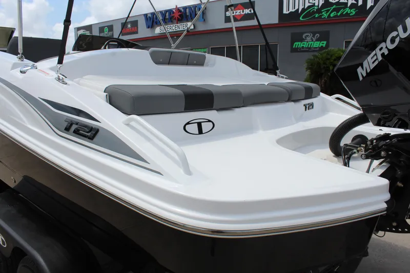 Slide: The Image of 2025 Tahoe T21 boat with sleek design and Mercury engine, displayed at a dealership. - 8
