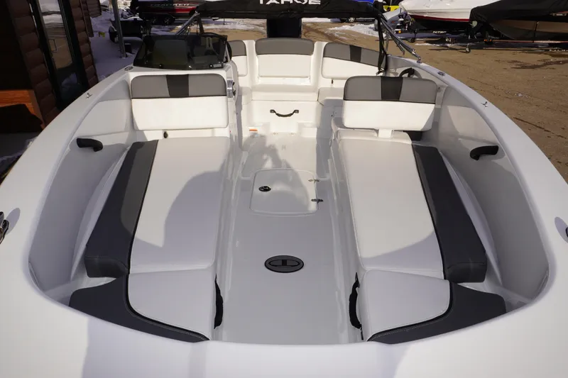 Slide: The Image of 2025 Tahoe T18 boat interior with white and gray seating, docked outdoors. - 4