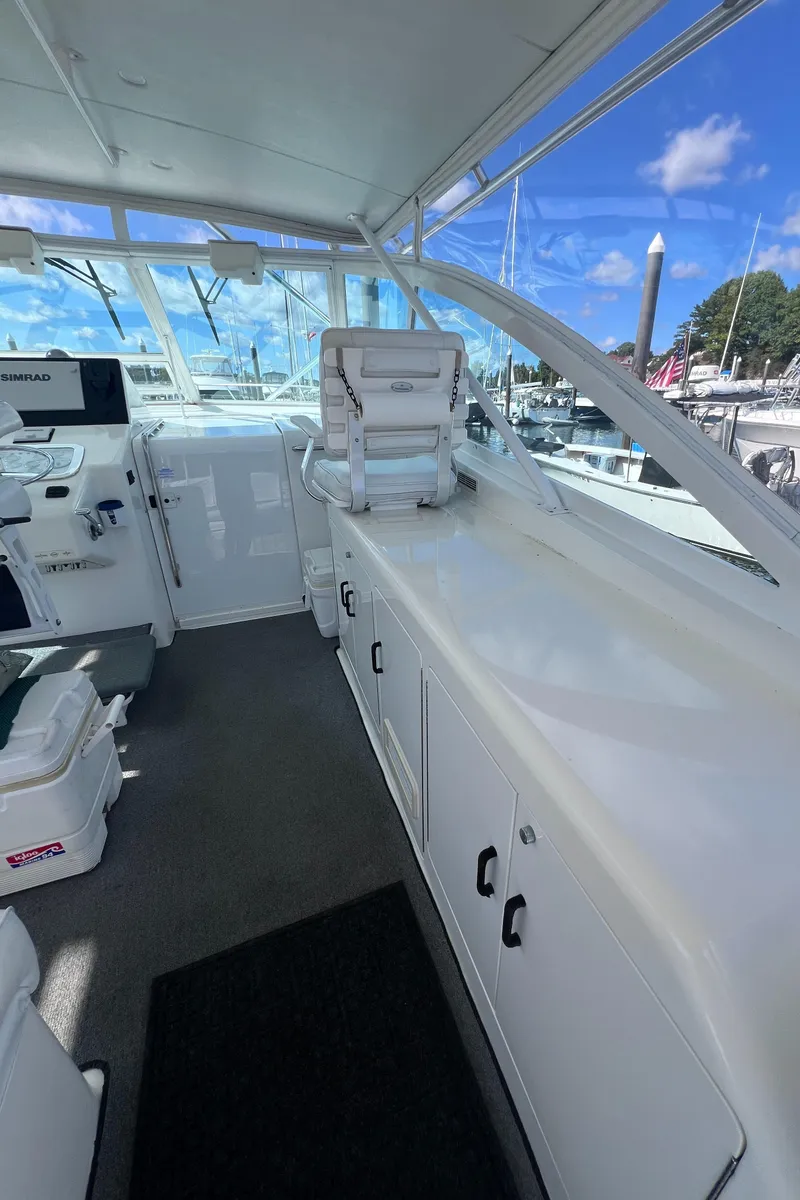 Slide: The Image of 2001 Cabo 45 Express boat interior with helm and seating area. - 11