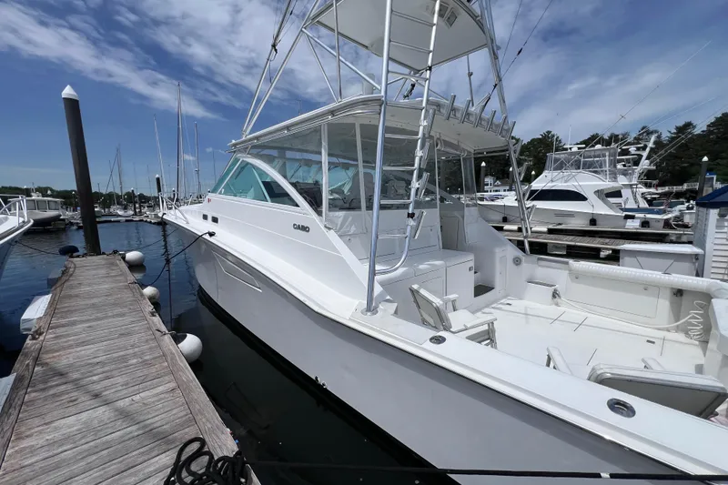Slide: The Image of 2001 Cabo 45 Express yacht docked at marina under clear blue sky. - 12