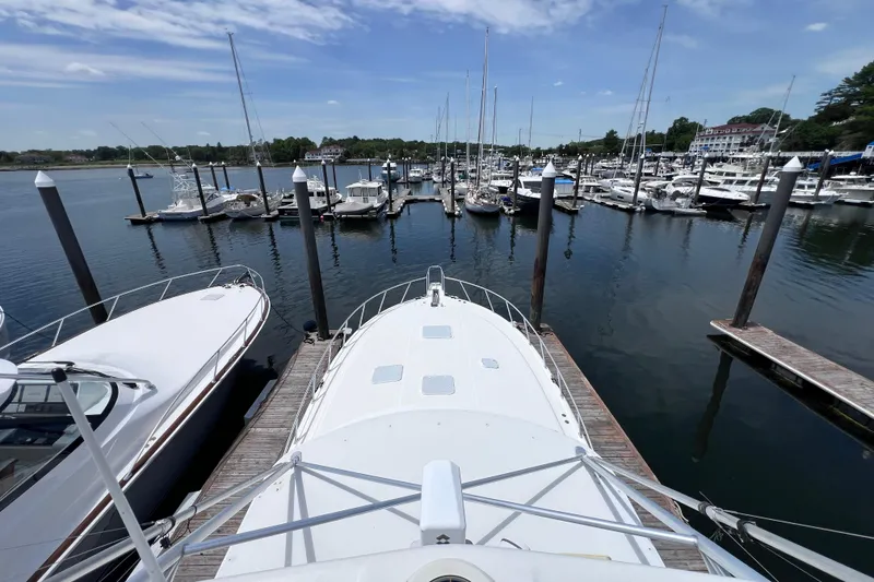 Slide: The Image of 2001 Cabo 45 Express yacht docked at a marina with other boats. - 13