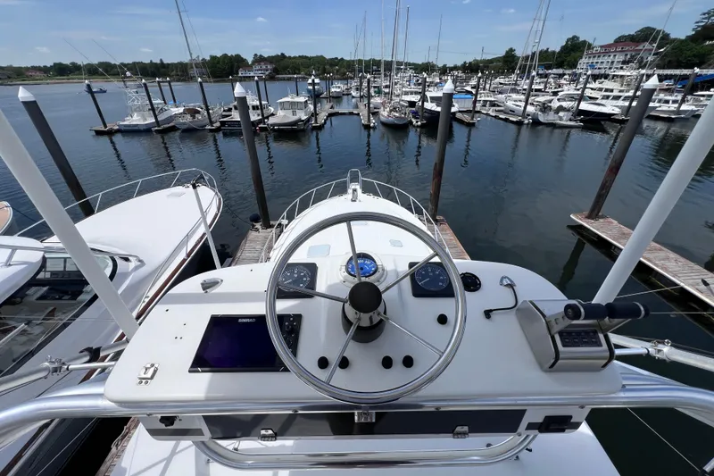Slide: The Image of Helm view of 2001 Cabo 45 Express yacht docked at marina. - 14