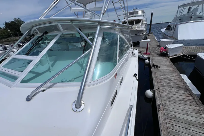 Slide: The Image of 2001 Cabo 45 Express yacht docked at marina, showcasing sleek design and spacious deck. - 17