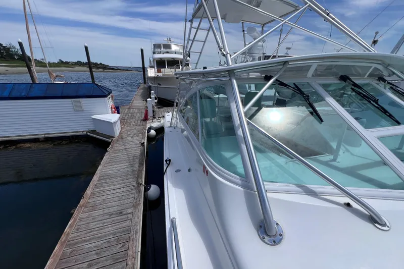Slide: The Image of 2001 Cabo 45 Express yacht docked at a marina under a clear blue sky. - 18