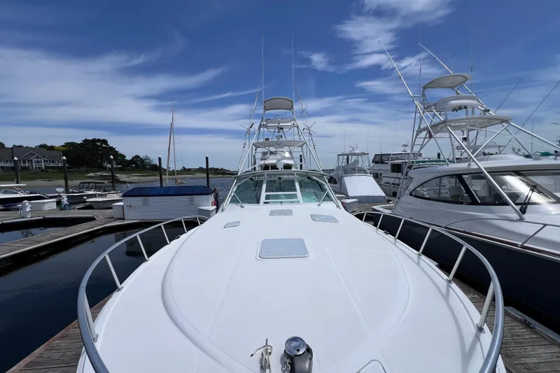 Slide: The Image of 2001 Cabo 45 Express yacht docked at marina under clear blue sky. - 19