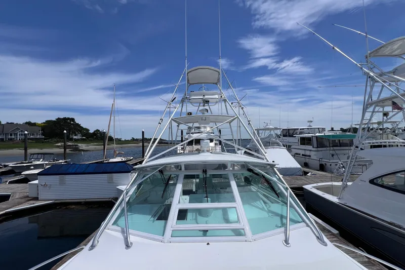 Slide: The Image of 2001 Cabo 45 Express yacht docked at marina under clear blue sky. - 20
