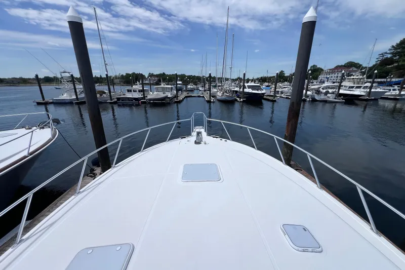 Slide: The Image of Bow view of a 2001 Cabo 45 Express yacht docked at a marina. - 21