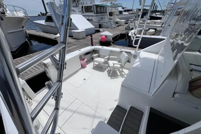 Slide: The Image of 2001 Cabo 45 Express yacht docked, featuring spacious deck and seating area. - 23