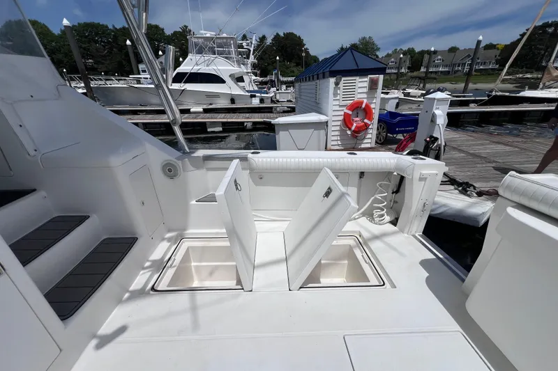 Slide: The Image of 2001 Cabo 45 Express yacht deck with open storage compartments at marina. - 29