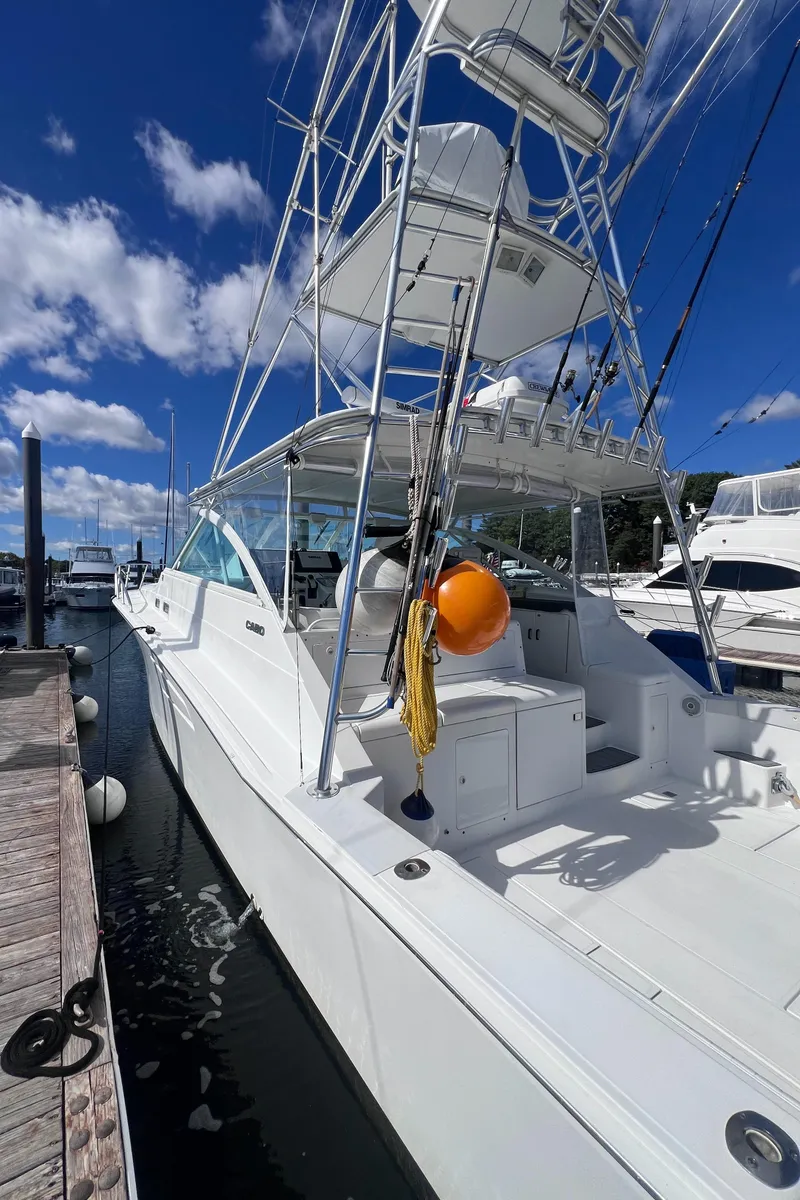 Slide: The Image of 2001 Cabo 45 Express yacht docked under a clear blue sky. - 3