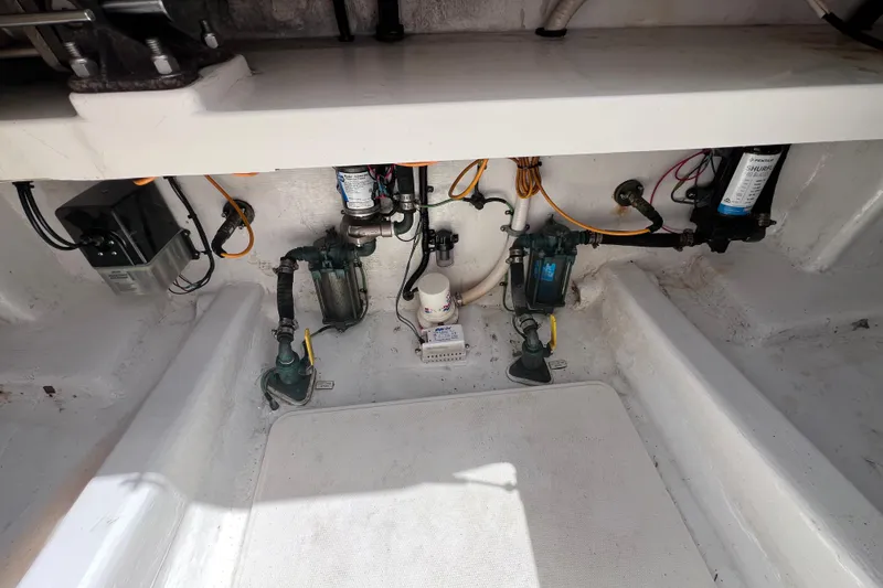 Slide: The Image of 2001 Cabo 45 Express boat engine compartment with pumps and wiring. - 30