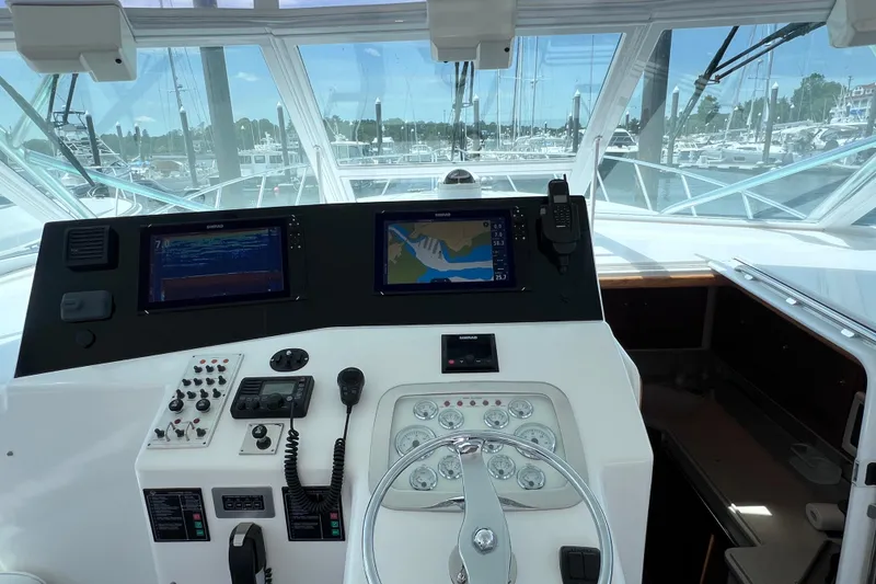 Slide: The Image of Control panel of a 2001 Cabo 45 Express boat with navigation screens and steering wheel. - 37