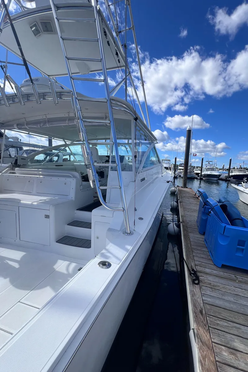 Slide: The Image of 2001 Cabo 45 Express yacht docked under blue sky. - 4