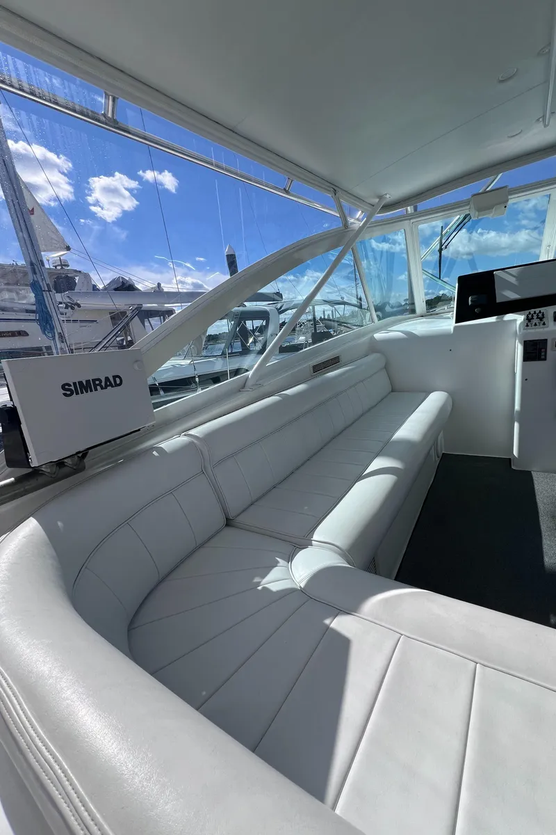 Slide: The Image of 2001 Cabo 45 Express yacht interior with white seating and navigation equipment. - 9