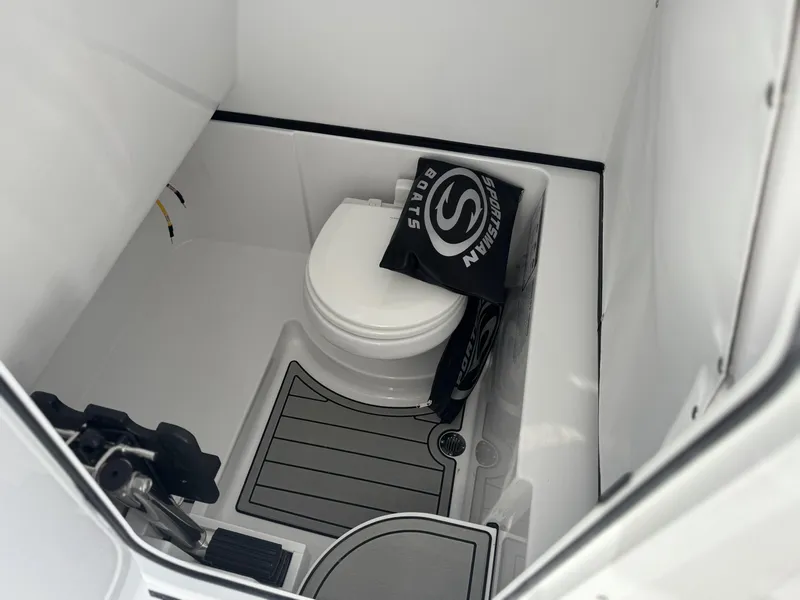 Slide: The Image of 2025 Sportsman Open 262 Center Console boat interior with toilet and storage area. - 19