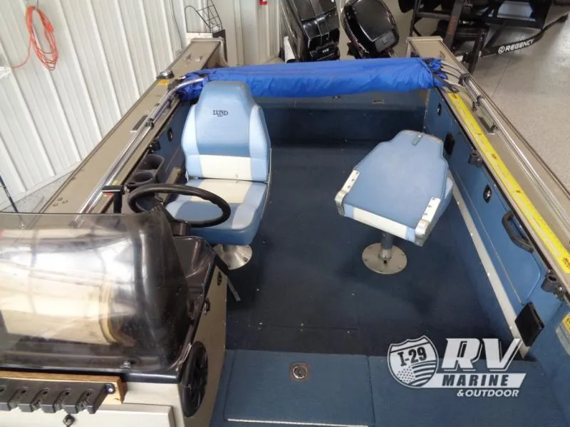Slide: The Image of 1994 Lund 1775 Pro V boat interior with blue seating and steering console. - 22
