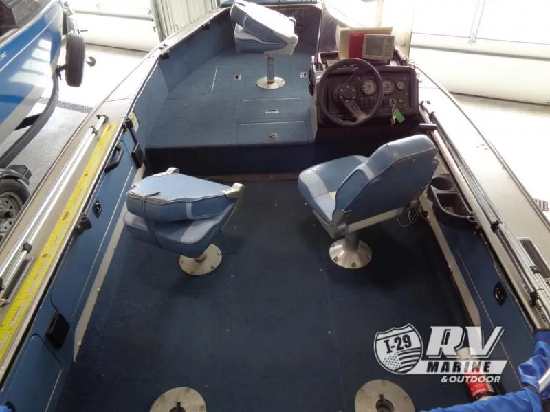 Slide: The Image of 1994 Lund 1775 Pro V boat interior with blue seating and steering console. - 24