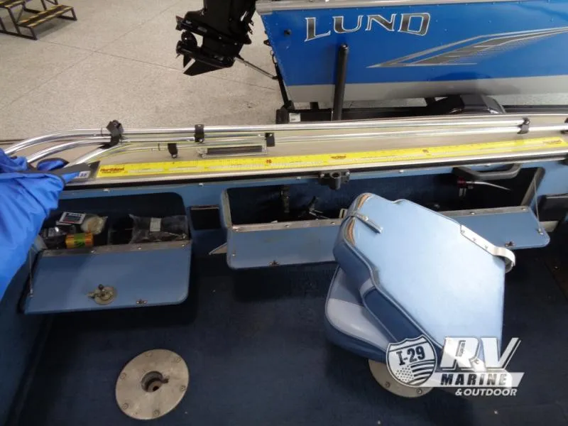 Slide: The Image of 1994 Lund 1775 Pro V boat interior with storage compartments and blue seating. - 25