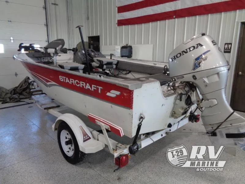 Slide: The Image of 1999 Starfire 160 boat with Honda outboard motor in a garage setting. - 4
