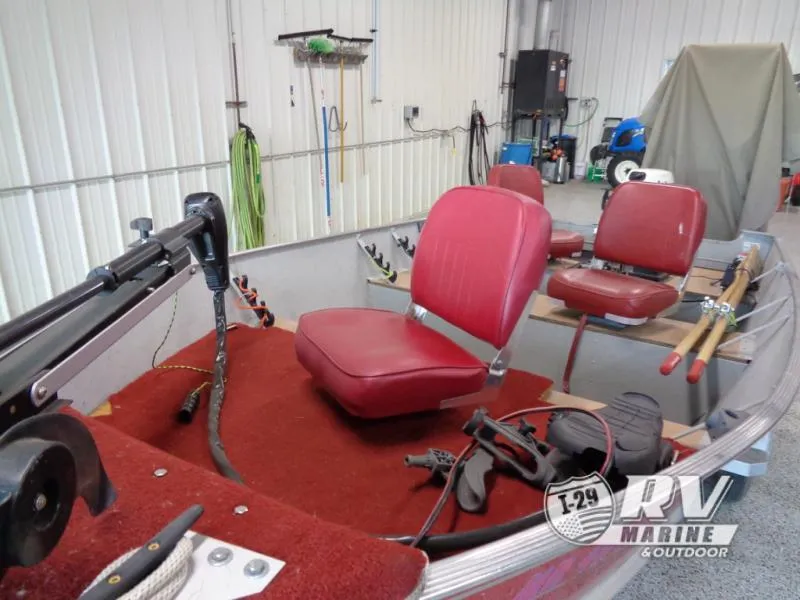 Slide: The Image of 2004 SSV 14 boat interior with red seats and fishing gear in a garage. - 6