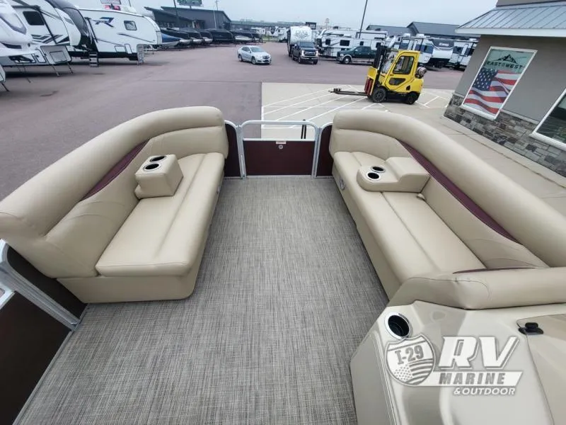 Slide: The Image of 2018 Cruisers 2086 pontoon boat interior with beige seating, cup holders, and spacious layout. - 10