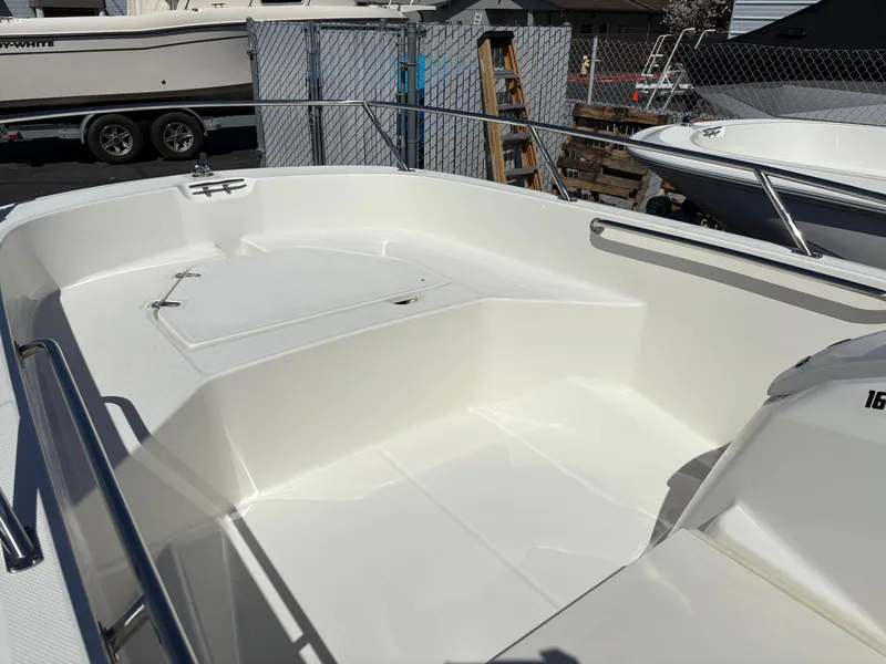 Slide: The Image of 2025 Boston Whaler 160 Super Sport boat interior, featuring spacious white deck and seating area. - 5
