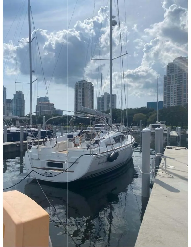 Slide: The Image of 2017 Jeanneau Sun Odyssey 44 DS sailboat docked in a marina with city skyline. - 27